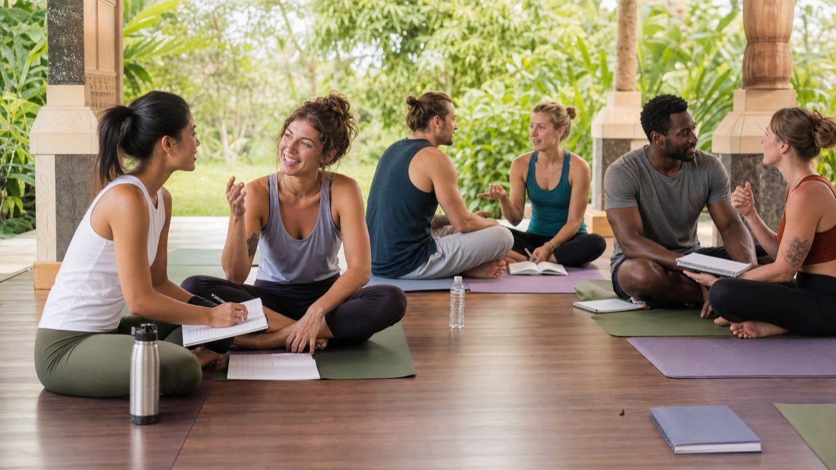 International hybrid training community International hybrid yoga teacher trainees exchanging practical peer feedback in pairs after arriving for their Bali intensive