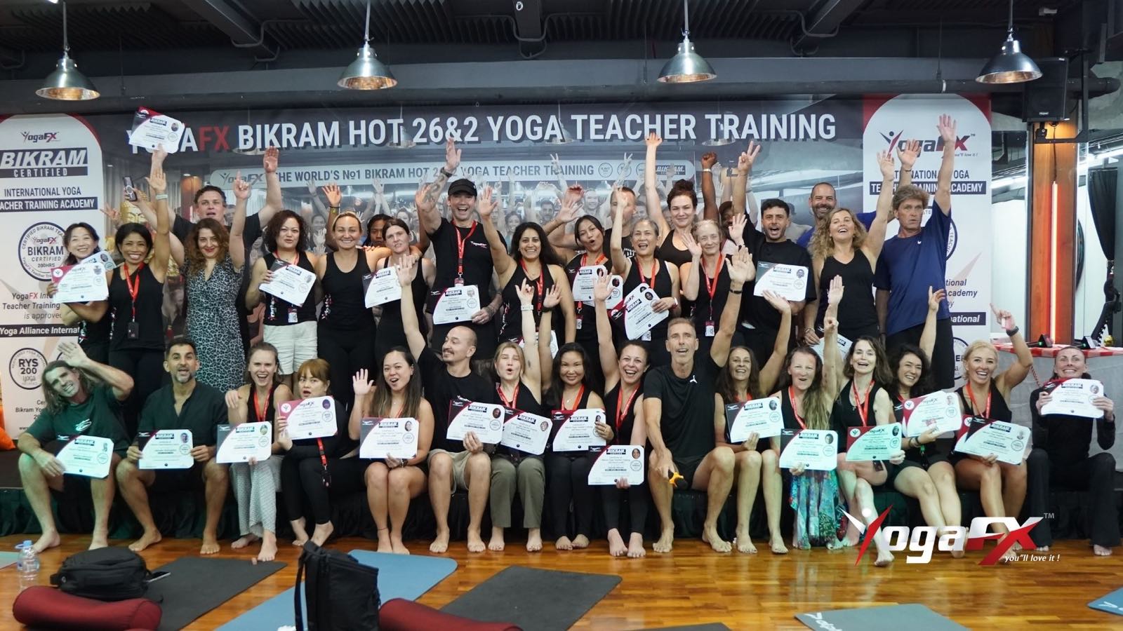 YogaFX Bikram Hot 26&2 yoga teacher training graduates holding their certificates