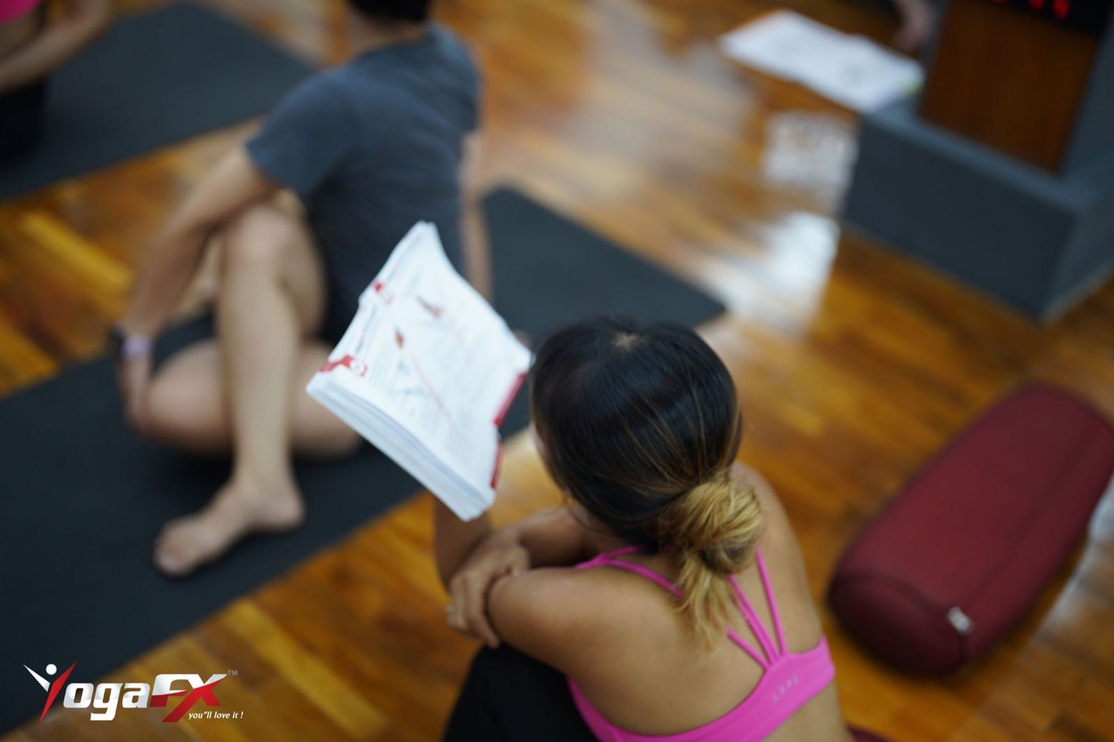 YogaFX Bikram Hot Yoga teacher training student reviewing a course manual