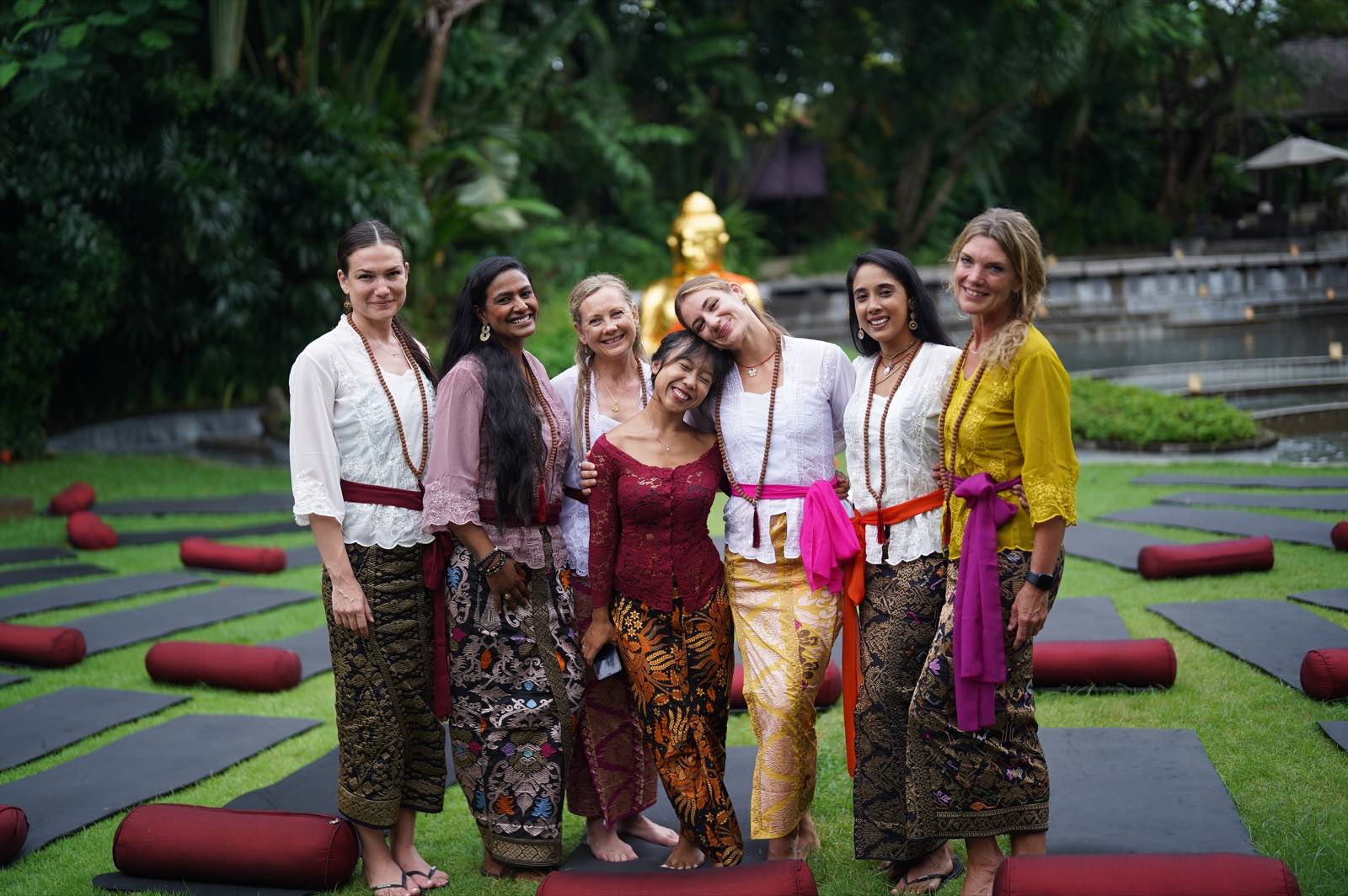 YogaFX yoga teacher training students wearing traditional Balinese clothing in a tropical Bali setting